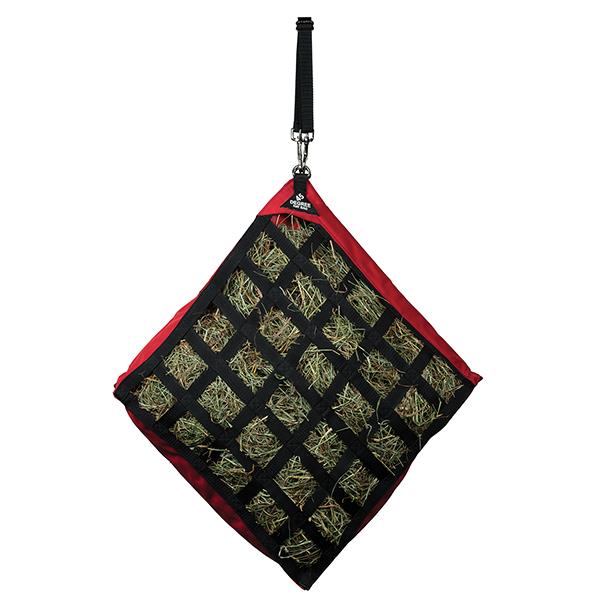 a red slow feed hay bag for horses hanging at a 45 degree angle on a white background