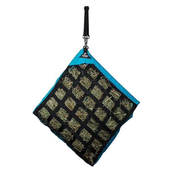 a blue slow feed hay bag for horses hanging at a 45 degree angle on a white background